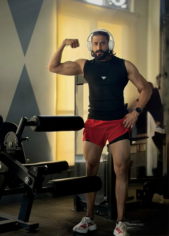 Nicky Raj flexing in the gym.